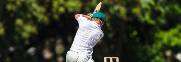 Back of a cricket batsman with green helmet