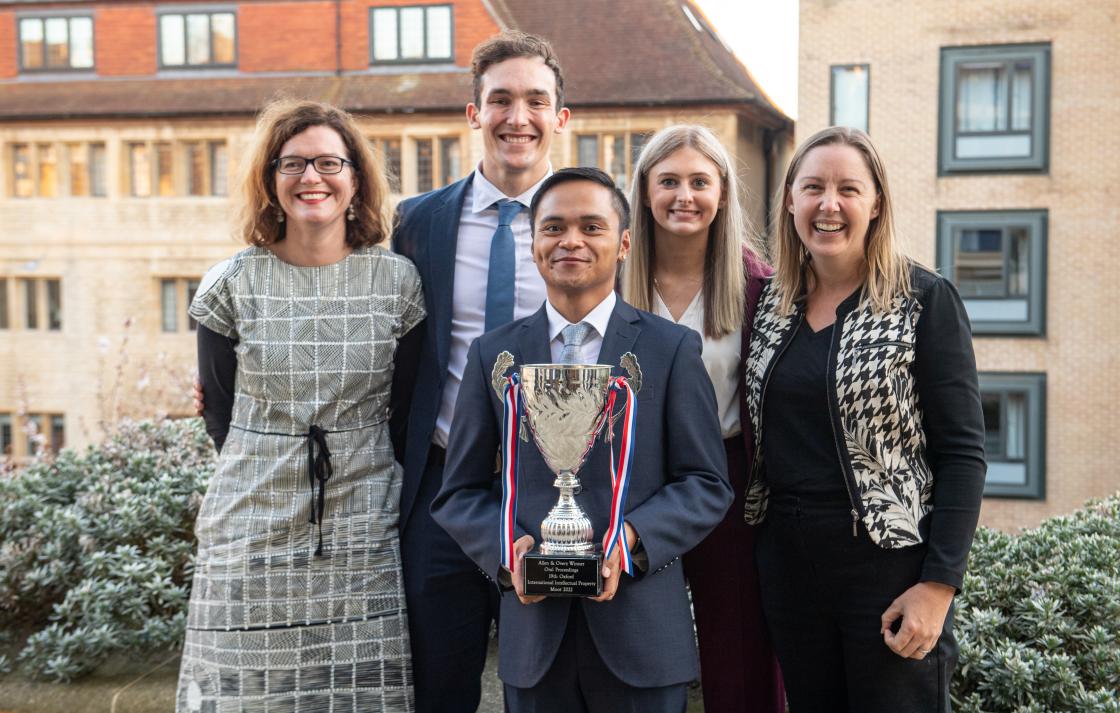 prize winners holding mooting cup