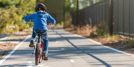 Young boy riding bike on a path
