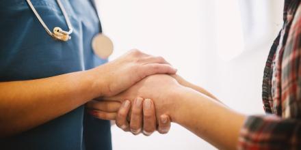 Health nurse holding patients hand