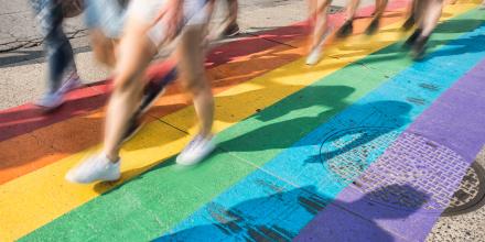 People walking over a rainbow crossing