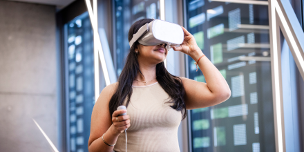 Female IT student with VR goggles on within Building 11