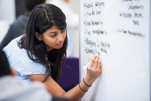UTS student writing on a white board