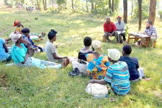 Bunch of women sitting on the grass, and part of the research in Uganda 