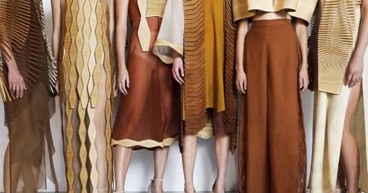 Close-up of fashion outfits worn by six models. The clothes are made from silk and wool in warm brown and cream tones. All include edgings or overlays made of laser-cut wood.