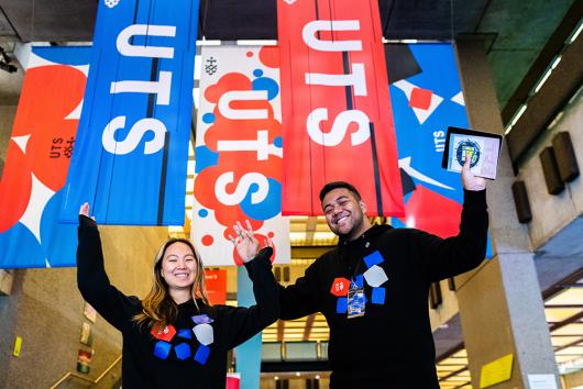 Two UTS students stand in front of UTS banners at Open Day.