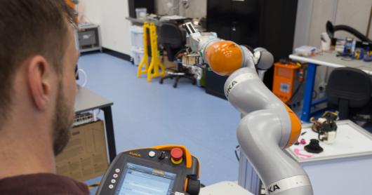 A researcher sends commands to a robot.