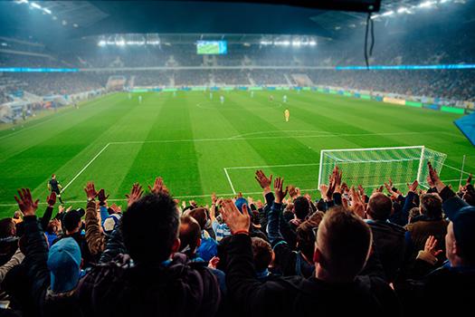 Fans watch a soccer match in a stadium