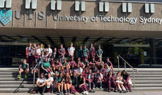 group photo of high school students sitting on the steps of UTS Tower building