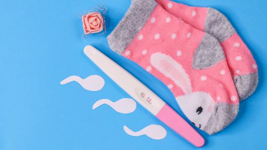 pregnancy test, baby socks and sperm shapes