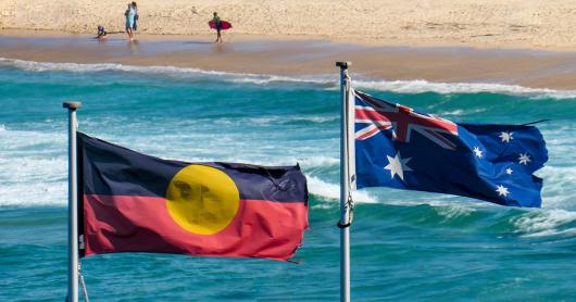 The Aboriginal and Australian flag flying side by side, Bondi Beach in background