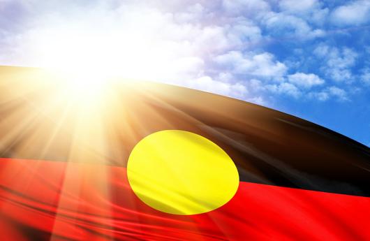 Stock picture of the Aboriginal flag against a sunny sky