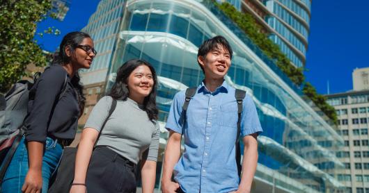 Three students stand in front of UTS Central looking out across campus.