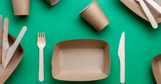 a stock photo of compostable packaging food containers, including a fork and a knife.