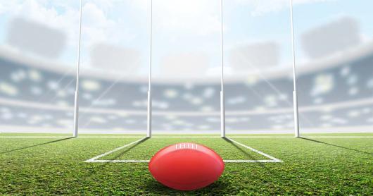 A football siting in the foreground of a sports field
