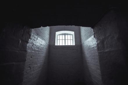 Prison cell with light shining through the bars