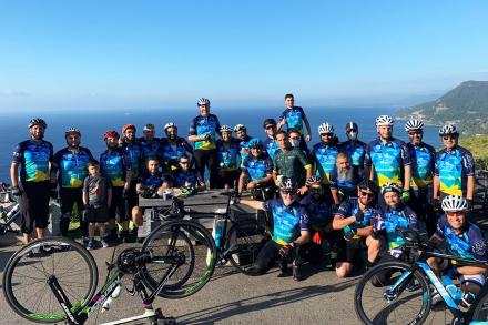 Many bike riders in front of spectacular coastal scenery