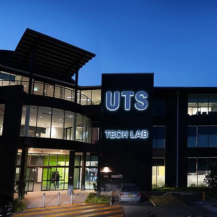 A lit up building at dusk. The sign out the front reads "UTS Tech Lab".