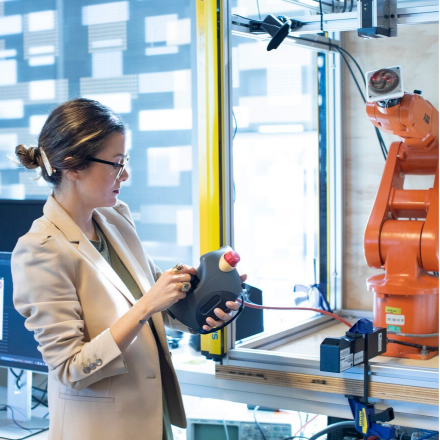 woman looking at a Robotic arm