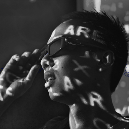 Student with sunglasses, text projected on their face, black and white