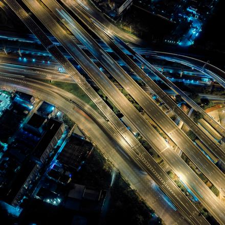 Aerial view of multi lane overhead freeway system with blue toned lights