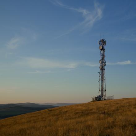 Communication tower in countryside with sun setting