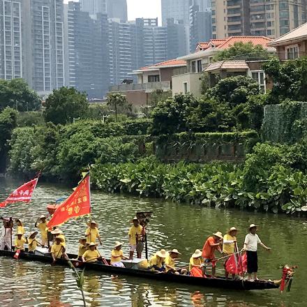 Traditional boat, meandering river, city backdrop