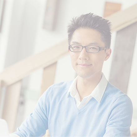 Young Asian man wearing glasses and a light blue jumper in an office