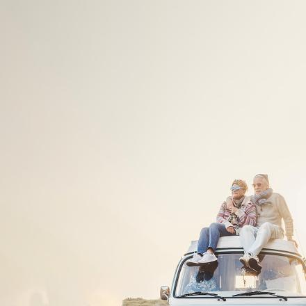 Elderly couple sitting on the top of a van.
