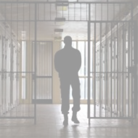 Person walking through prison hallway gates.
