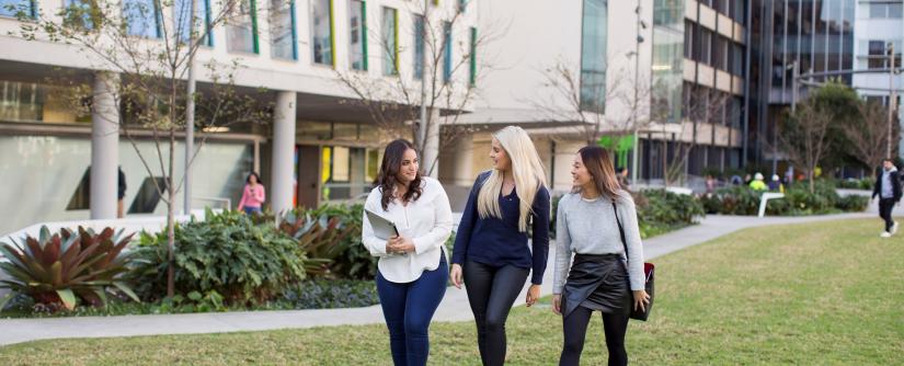 Three females walking on campus