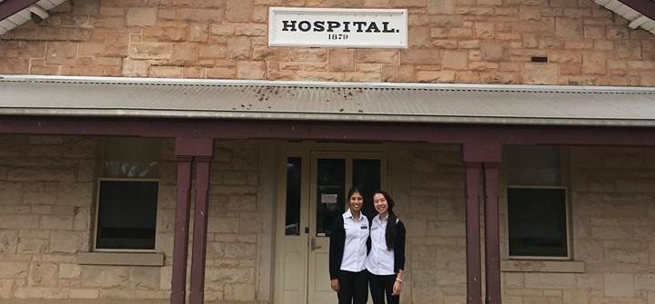 Two female students in front of hospital