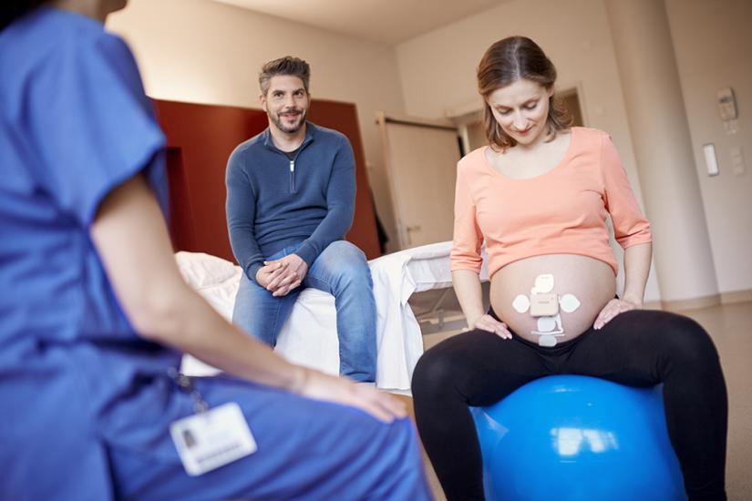 Woman with fetal monitoring device on exercise ball