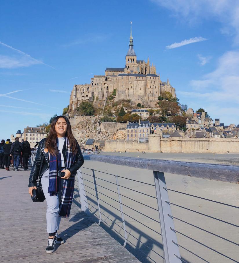 FASS France ICS study tour Nicole walking on a path with a large castle in the background