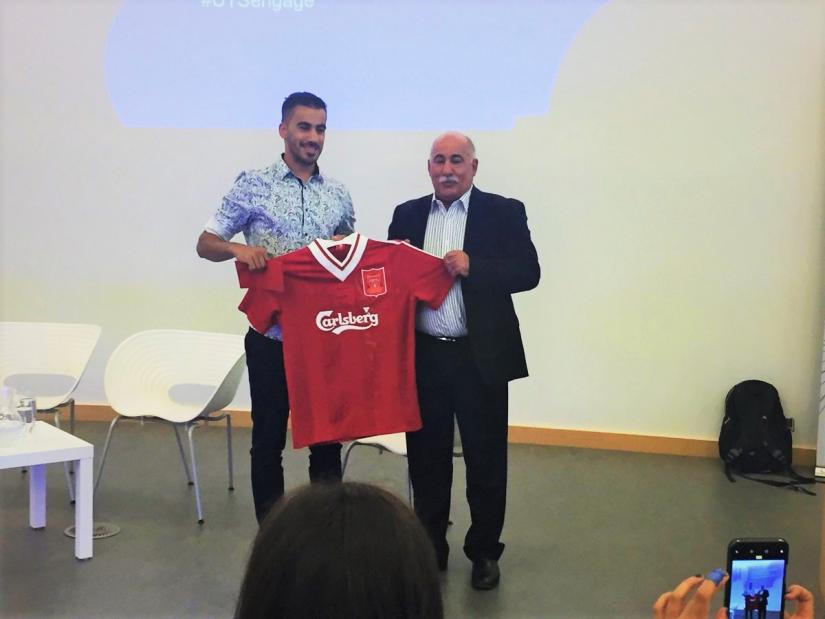 Hakeem Al-Araibi is presented with a shirt signed by Liverpool legend Robbie Fowler