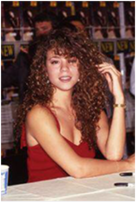 A young Mariah Carey in a red dress with curly hair