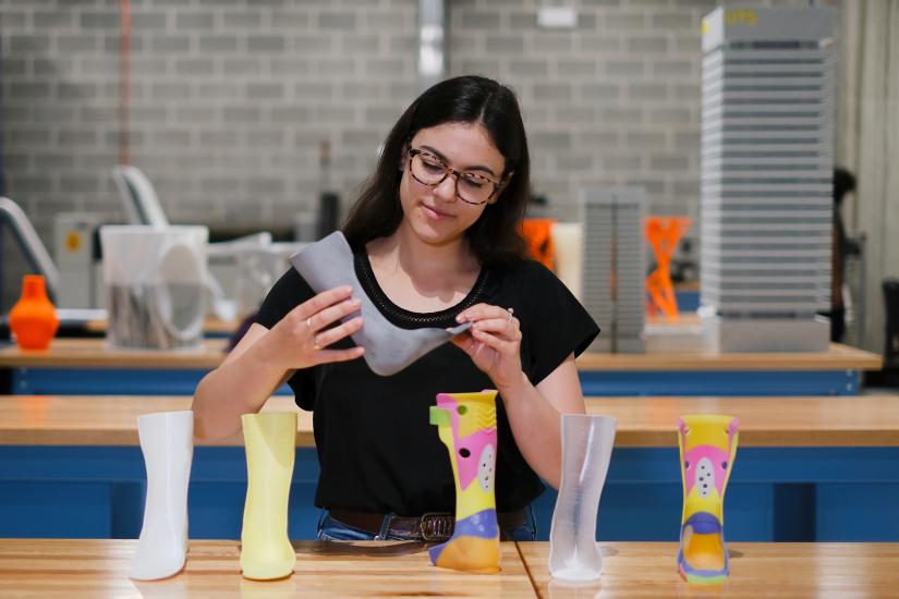 Mechanical and mechatronic engineering student Kate Leone holding a 3D printed ankle-foot orthosis.