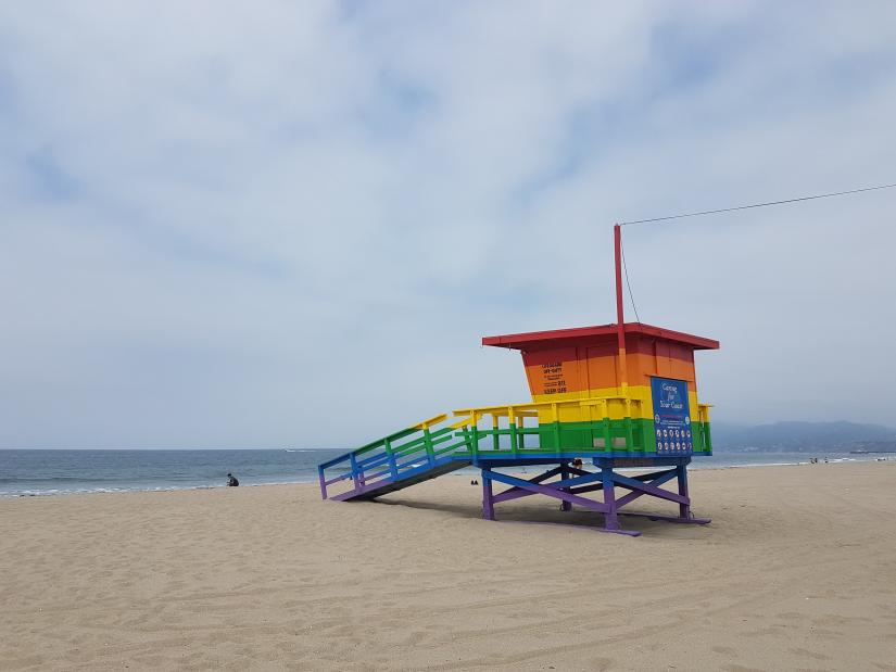 A rainbow-painted shack on a beach