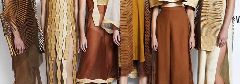 Close-up of fashion outfits worn by six models. The clothes are made from silk and wool in warm brown and cream tones. All include edgings or overlays made of laser-cut wood.