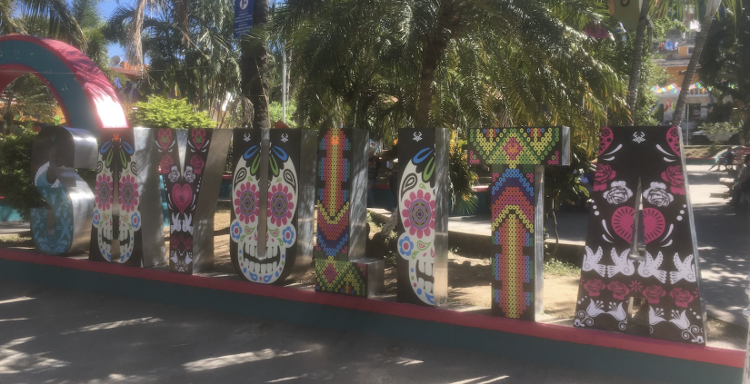 A sign painted in traditional Mexican art