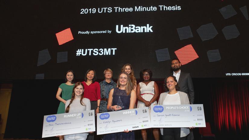 Finalists of the UTS Three Minute Thesis (3MT) competition, 2019. Front row: Winner Katelyn Bywaters, Institute for Sustainable Futures (centre), Runner-up Elena Meshcheriakova, Faculty of Business (left), and People's Choice Samara Garrett, Faculty of Science (right)