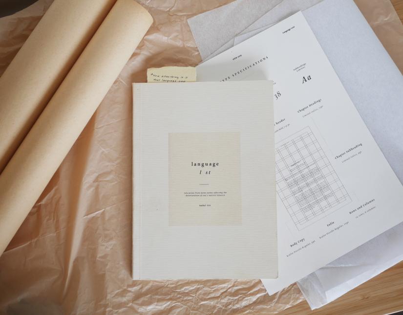 Rachel Tse's book Language L st lays on papers including a type specifications document