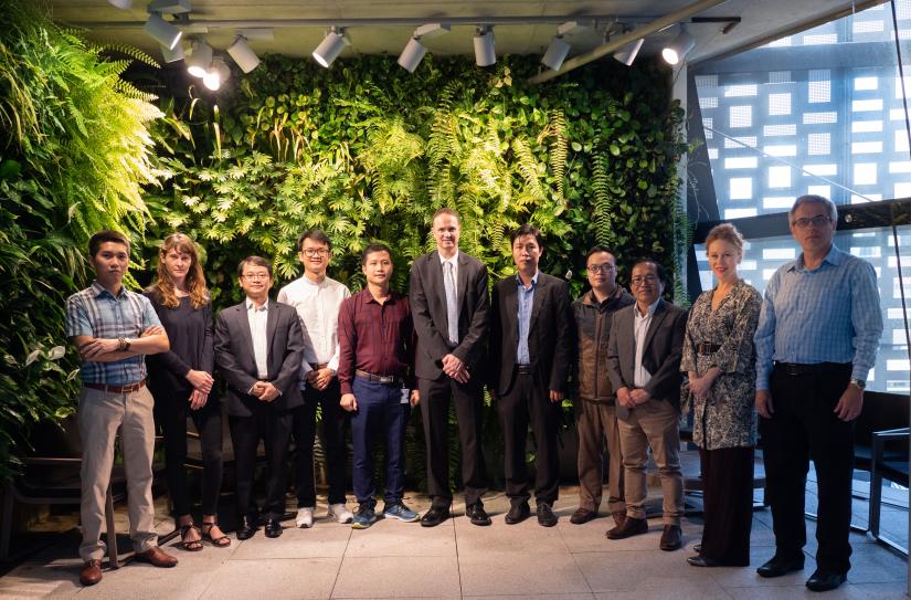 A group of people in front of a vertical garden