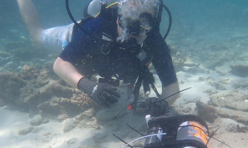 Marine biologist David Hughes installing an oxygen sensor on the Heron Island Reef.