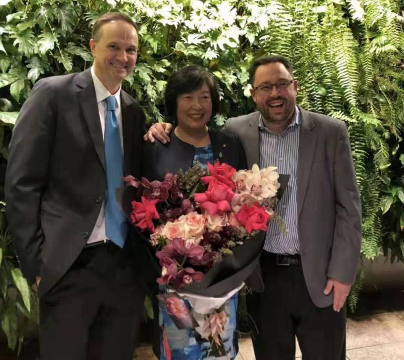 Professor Ian Burnett (left) and Professor Michael Blumenstein congratulate Distinguished Professor Jie Lu (who is holding a huge bunch of flowers) on her achievement as the first UTS academic to be awarded an Australian Laureate Fellowship
