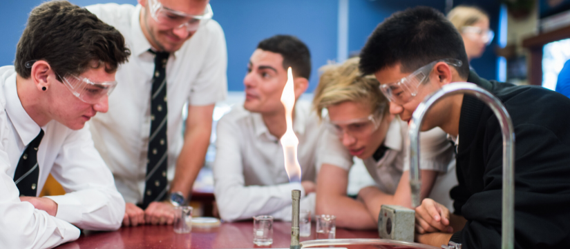 Student in classroom setting with bunsen burner