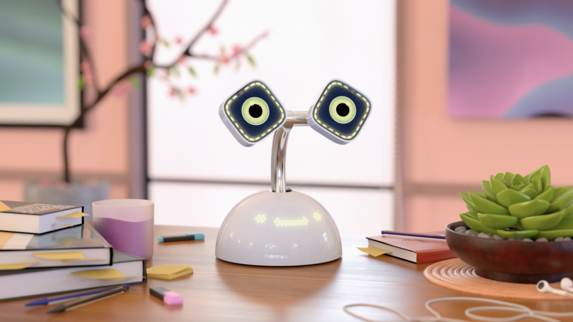 A white desktop robot with animated green eyes