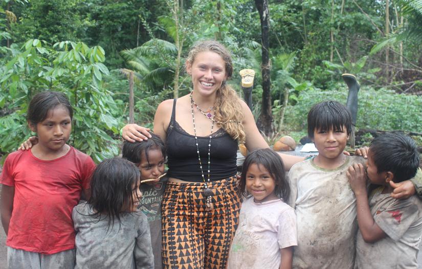 Young woman surrounded by cute children in the Amazon