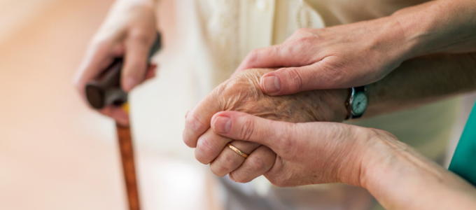Nurse holds the hand of an elderly patient
