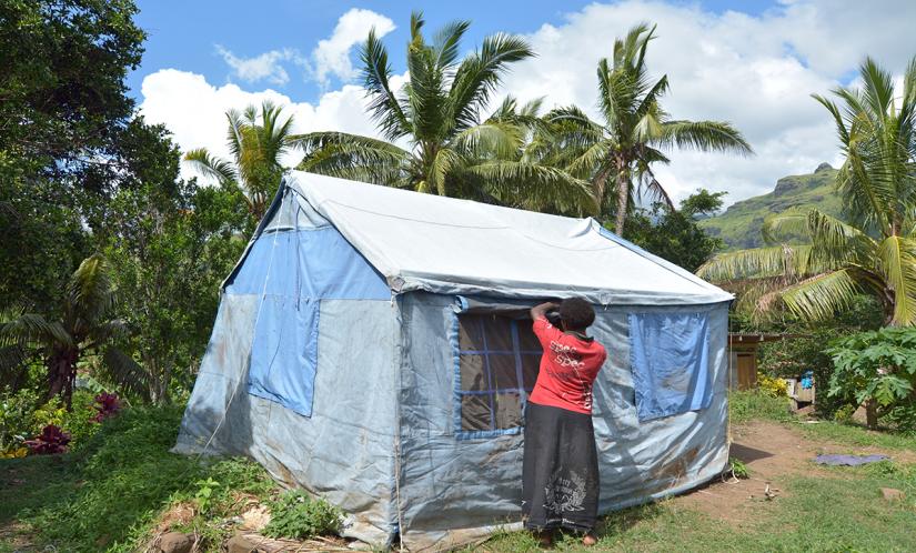 A woman fixes an emergency tent in the Pacific Islands